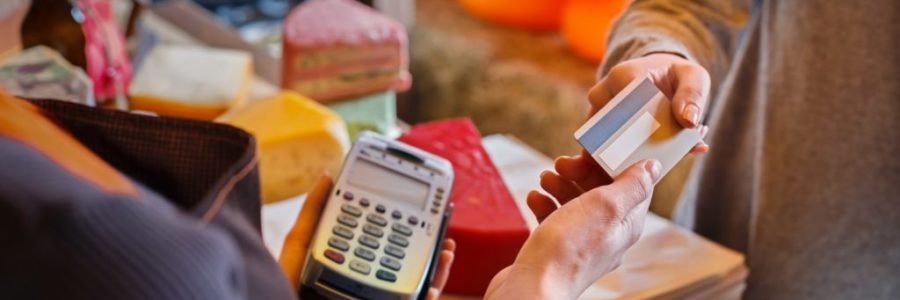 Customer paying for order of cheese in grocery shop. Customer paying for order of cheese in grocery shop.