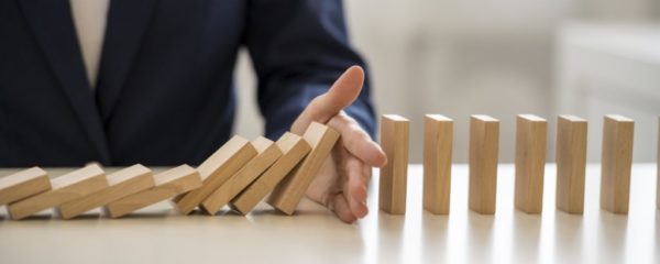 Hand stopping falling blocks on table