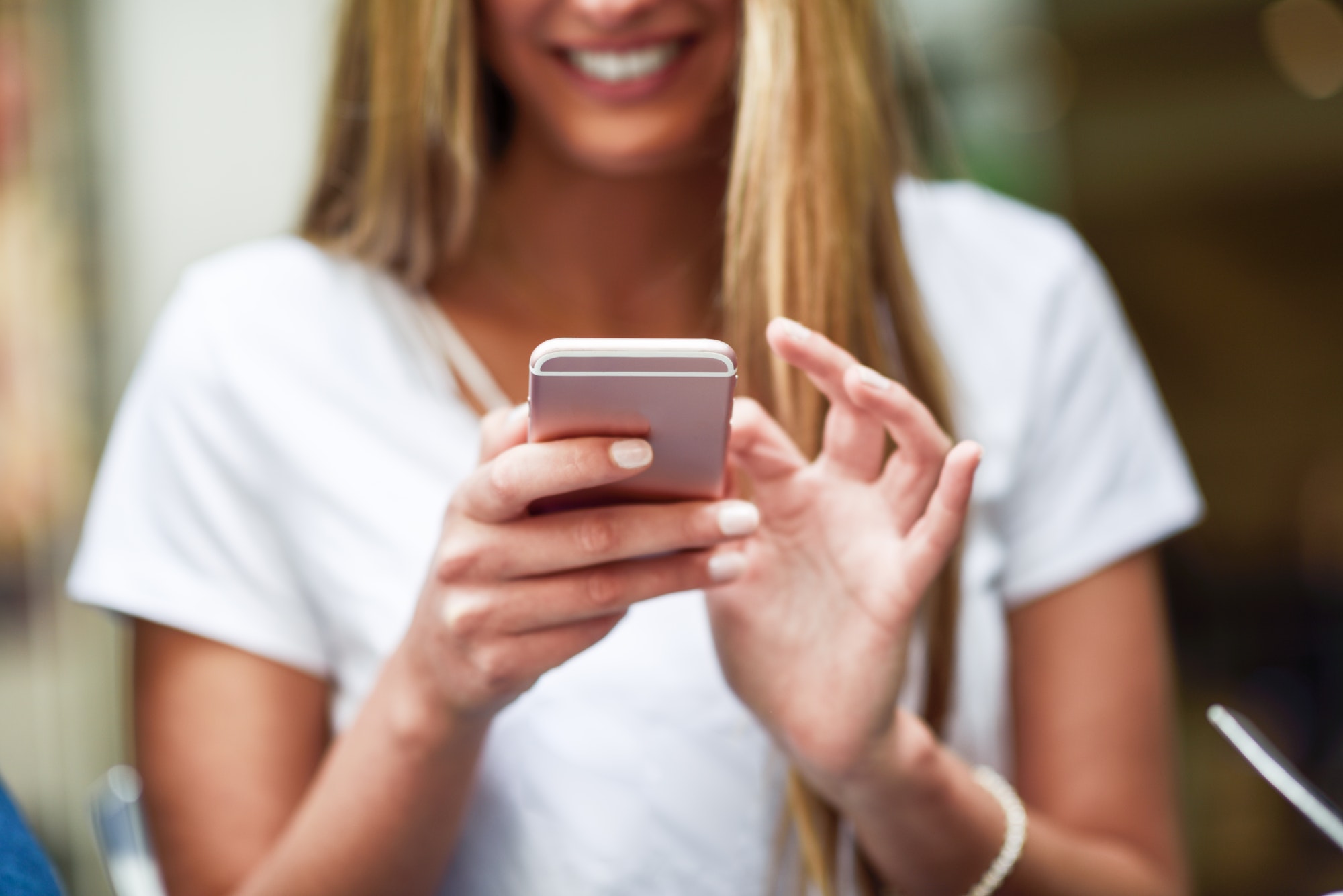 Close-up image of young blonde girl texting with smartphone