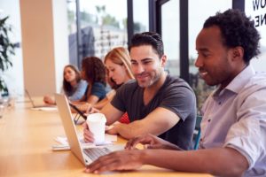 Businessmen And Businesswomen Working In Shared Open Plan Office Workspace