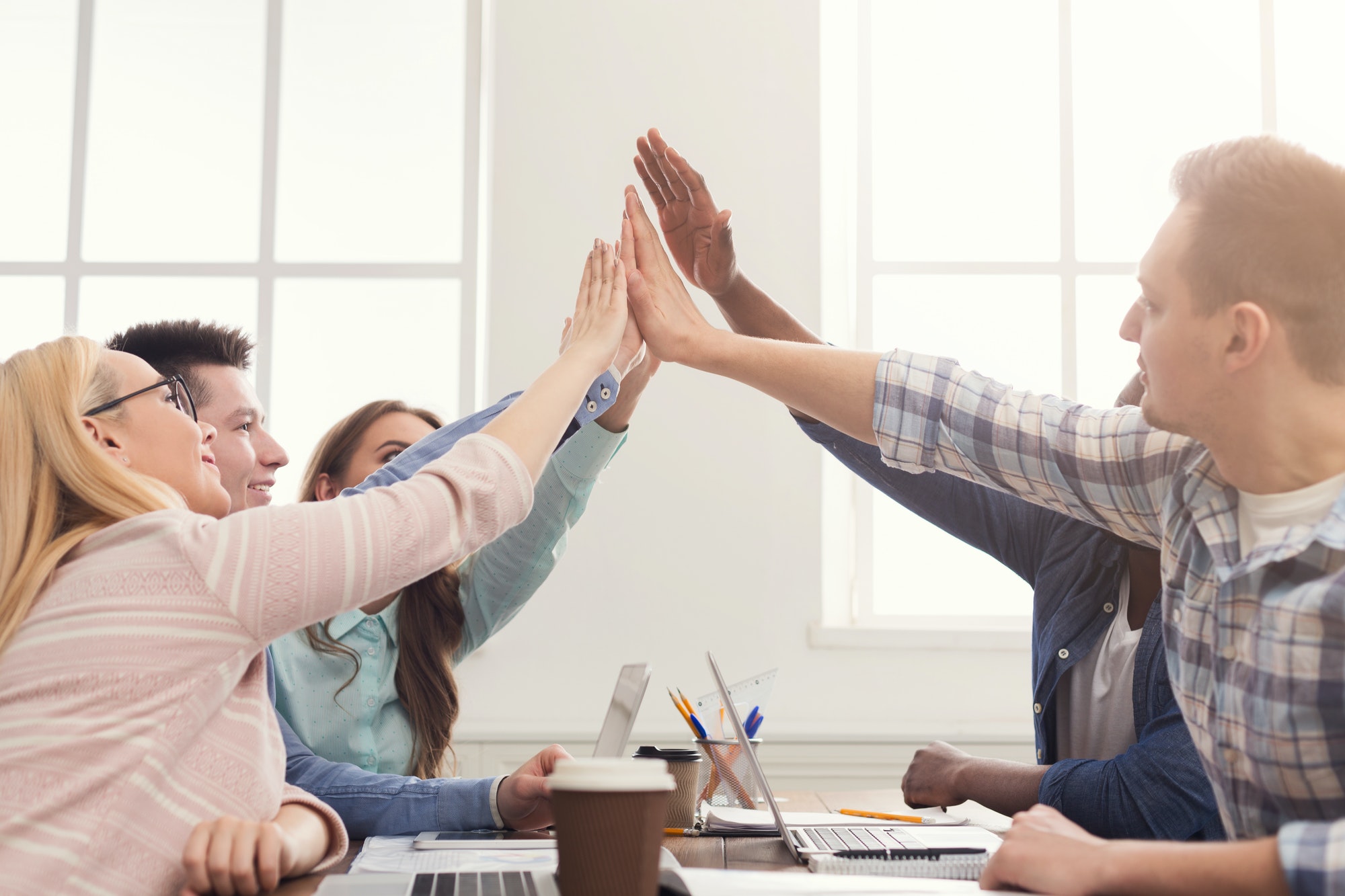 Successful young business team is giving high five