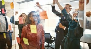 Cheering businesspeople celebrating success after brainstorming together in an office