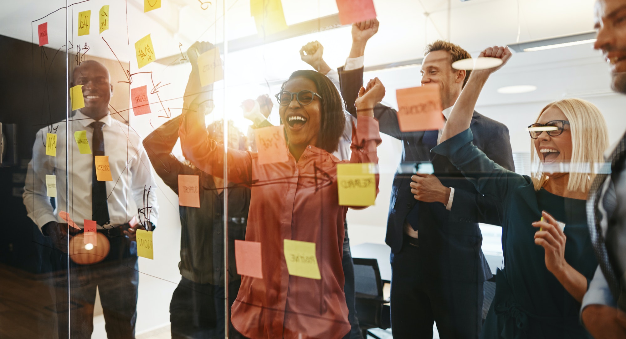 Ecstatic businesspeople celebrating success after an office brainstorming session