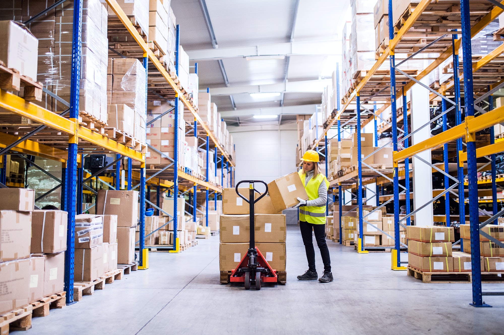 Female warehouse worker loading or unloading boxes.