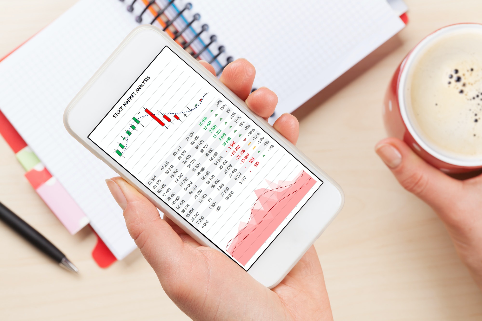 Woman holding smartphone above business desk