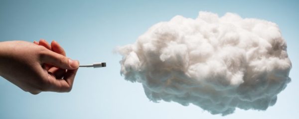 Woman's hand plugging a wire into a white cloud. Woman's hand plugging a wire into a white cloud.