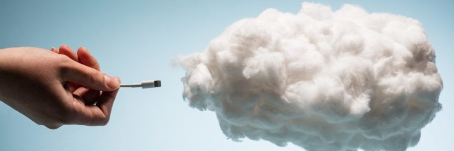 Woman's hand plugging a wire into a white cloud. Woman's hand plugging a wire into a white cloud.