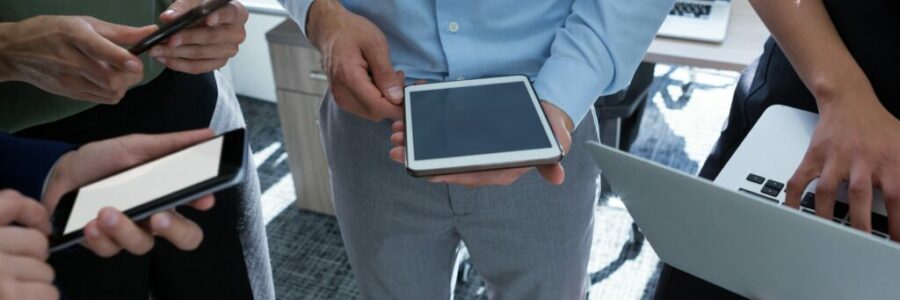 Executives using mobile phone, laptop and digital tablet in the office Executives using mobile phone, laptop and digital tablet in the office