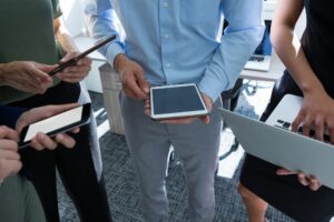 Executives using mobile phone, laptop and digital tablet in the office